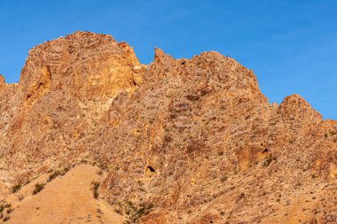 Overton, Nevada, ABD - 24 Şubat 2010: Ateş Vadisi. Mavi gökyüzünün altındaki altın dağ sırtına yakın..