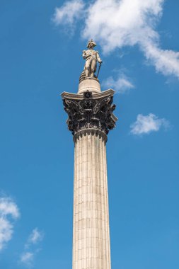 London, UK- July 4, 2022: Trafalgar Square. Frontal view on Nelson on top of his column, isolated against blue cloudscape.