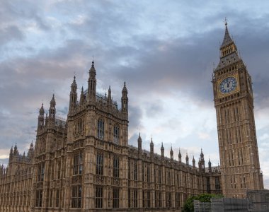 London, UK - July 4, 2022: Big Ben and corner of Westminster Palace under gray cloudscape,