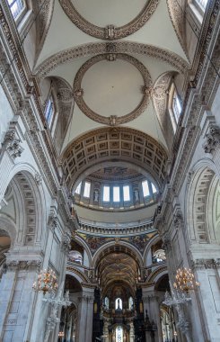 London, England, UK - July 6, 2022: St. Paul's Cathedral. Nave ceiling looking eastwards. Decoration by paintings, statues, golden and stone ornaments, lanterns, and part of inside dome.