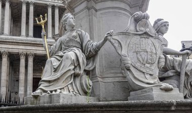 London, England, UK - July 6, 2022: St. Paul's Cathedral. Britannia and France figures at Statue of Queen Anne on West churchyard. Gray marble with golden trident. Columned facade