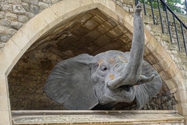 London, England, UK - July 6, 2022: Tower of London. Fake gray elephant head sticks out of stables built under ramparts.
