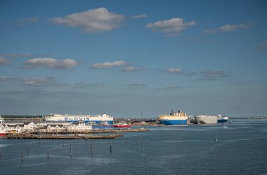 Southampton, İngiltere - 7 Temmuz 2022 Liman manzarası. SE limanının sonundaki limanda mavi bulutların altında birkaç büyük araba taşıyıcısı gemisi var..