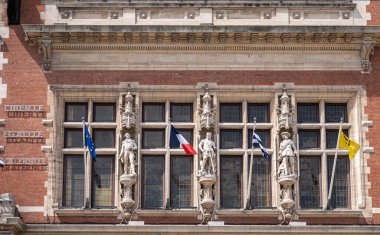 Avrupa, Fransa, Dunkerque - 9 Temmuz 2022: Birkaç ulusal bayrakla birlikte tarihi belediye binasının sağ tarafındaki 3 heykelin kapatılması.