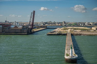 Avrupa, Fransa, Dunkerque - 9 Temmuz 2022: Canal de Bourbourg kilidi, kendi rıhtımı ve mavi bulutların altındaki ışık kulesi ile ana giriş. Dikey köprü yolu ve liman kurulumları