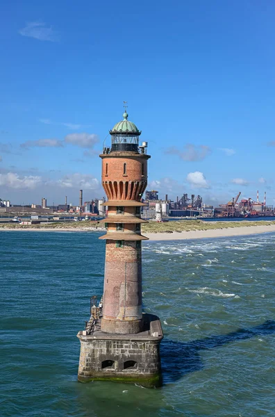 Avrupa, Fransa, Dunkerque - 9 Temmuz 2022: Yakın plan, Feu de Saint Pol ışık kulesi mavi gökyüzünün altındaki limanın girişinde iskelesini gizliyor. Enerji üretim tesisleri ve kömür ikmal iskelesi arkada.