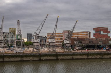 Antwerpen, Flanders, Belçika - 10 Temmuz 2022 Scheldt Nehri rıhtımı boyunca. Modern arkadaşlık binası ve Red Heritage müzesi tarihi liman vinçlerinin arkasında, Sabah Bulutları