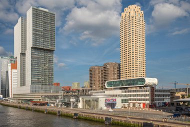 Rotterdam, Hollanda - 11 Temmuz 2022: Kop van Zuid rıhtımı ve iki en yüksek gökdeleni, New Orleans ve De Rotterdam limanı. Fotoğraf Müzesi ve gemi terminali mavi bulutların altında.