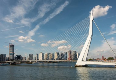 Rotterdam, Hollanda - 11 Temmuz 2022: Erasmusbrug, köprü. Manzara, mavi bulutlar altında güneye iniş. Boompjeskade 'de New Meuse nehrinin diğer yakasında yeni yüksek binalar.