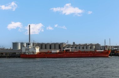Rotterdam, Hollanda - 11 Temmuz 2022: Kızıl TRF Bergen Norveç tankeri mavi akşam bulutu altında gaz terminaline yanaştı