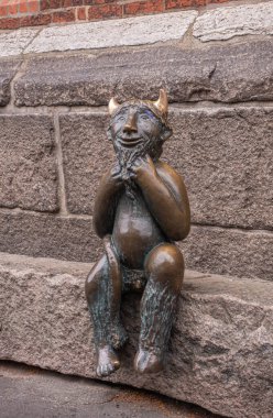 Almanya, Lubeck - 13 Temmuz 2022: Marienkirche 'in güney tarafında, Mary' nin kilisesi. Şeytanın taşında oturan şeytanı temsil eden küçük bronz bir heykel. Yerel mitoloji