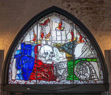 Almanya, Lubeck - 13 Temmuz 2022: Marienkirche, modern tarzda, renkli, boyalı kafatası ve alevlerin yer aldığı pencere 