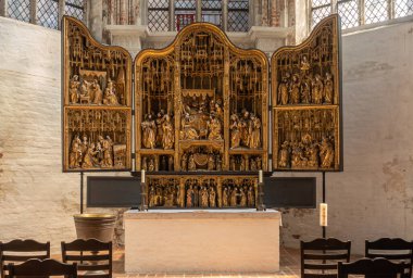 Almanya, Lubeck - 13 Temmuz 2022: Marienkirche. Antwerpener sunağı sunağın kenarında tamamen açıldı. Altın renkli ve bir sürü küçük insan figürlü sanat eseri.