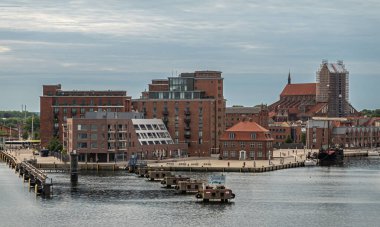 Almanya, Wismar - 13 Temmuz 2022: Hafenspitze rıhtımının batı ucu Stockholm rıhtımının sol tarafı ve sağ tarafı Alterhafen rıhtımı. Aziz Niklas kilise kuleleri