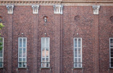 İsveç, Stockholm - 16 Temmuz 2022 Belediye veya Stadshuset. Tuğla üzerinde pencere ve heykeller Avlunun kuzey cephesinde