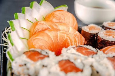 Salmon sashimi with salmon onigiri varieties on a plate. Closeup.