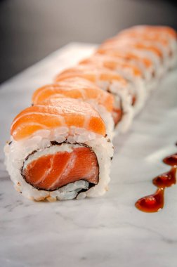 Uramaki salmon on marble plate. Closeup.