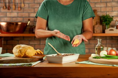 Brezilya usulü aperatifler hazırlayan kadın biftek doldurma kroketi (risolis de carne)) 