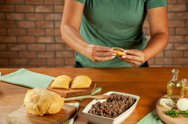 Brezilya usulü aperatifler hazırlayan kadın biftek doldurma kroketi (risolis de carne)) 