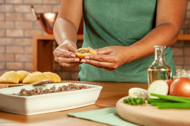 Brezilya usulü aperatifler hazırlayan kadın biftek doldurma kroketi (risolis de carne)) 