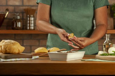 Brezilya usulü aperatifler hazırlayan kadın biftek doldurma kroketi (risolis de carne)) 