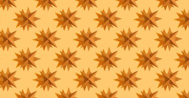 Pattern from glitter gold stars on beige background. New Year's or Christmas concept. Seamless pattern for wallpaper, background and textile. Greeting card. Banner or header