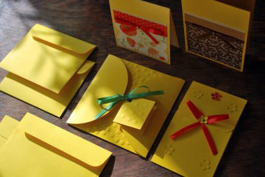 Sarı kartpostallar ve zarflar elle yapılmış ahşap bir masa üzerinde. Üst görünüm