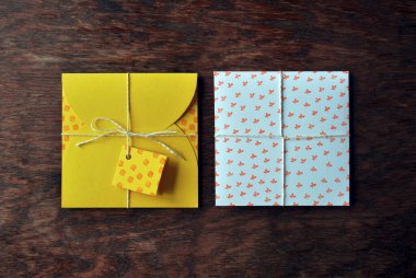 Sarı, beyaz zarf ahşap masanın üzerinde elle yapılmış. Düz yatış, üst görünüm