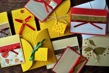 Tahta bir masada elle yapılmış kartpostallar ve zarflar. Düz yatış, üst görünüm