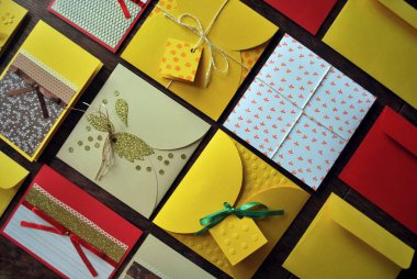 Tahta bir masada elle yapılmış kartpostallar ve zarflar. Düz yatış, üst görünüm