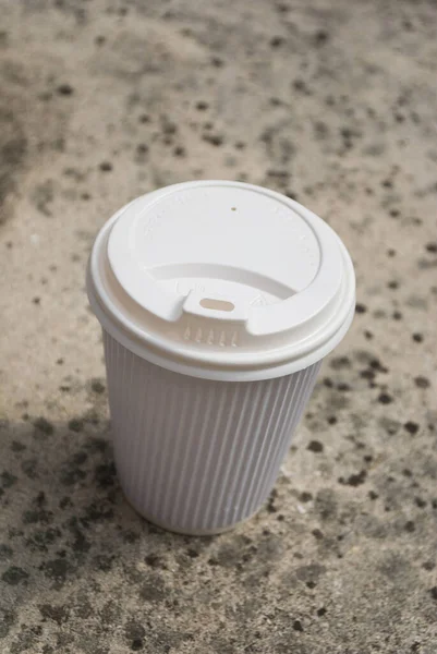 White paper cup of coffee takeaway. Paper cup of coffee on the table