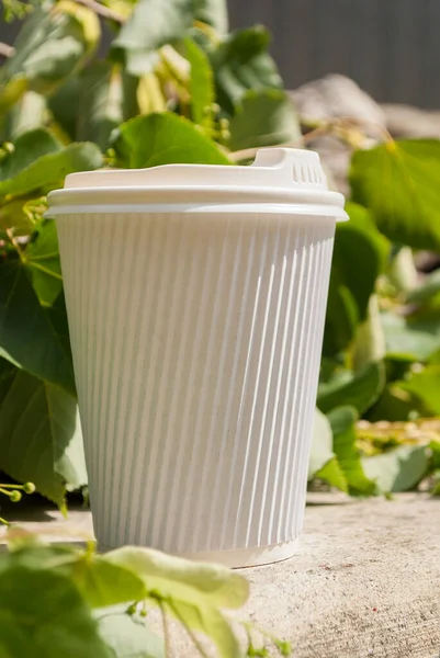 White paper cup of coffee takeaway. Paper cup of coffee on the table