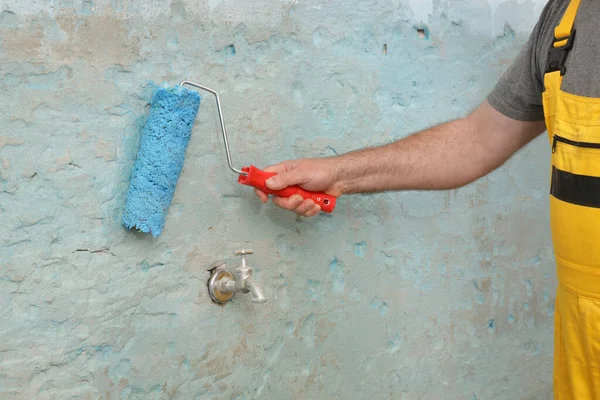 工人用涂料辊用胶粘剂底液粘贴瓷砖的手 图库图片