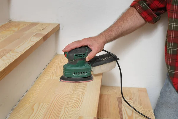 Closeup Worker Hand Sanding Wooden Stairs Using Powertool Stockfoto