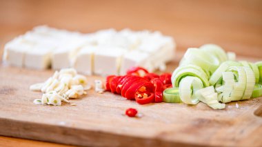 Peynir, pırasa, kırmızı biber ve doğrama tahtasında sarımsak..