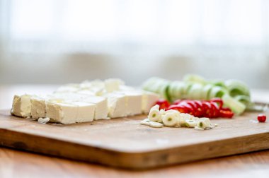 Peynir, pırasa, kırmızı biber ve doğrama tahtasında sarımsak..