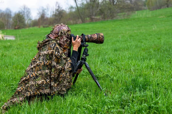 Bir kadın doğa fotoğrafçısı bir hayvanı bekliyor..