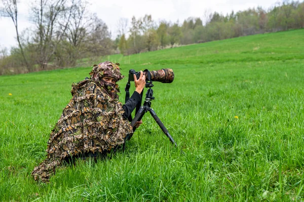 Bir kadın doğa fotoğrafçısı bir hayvanı bekliyor..