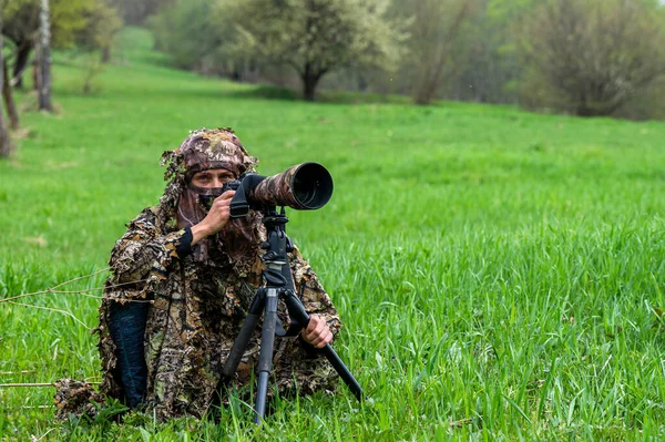 Bir kadın doğa fotoğrafçısı bir hayvanı bekliyor..