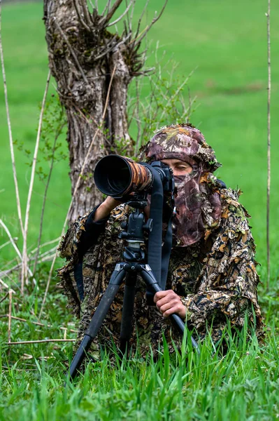 Bir kadın doğa fotoğrafçısı bir hayvanı bekliyor..