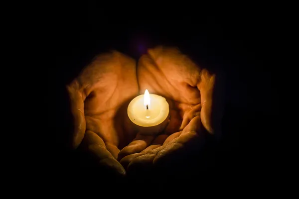 Mãos segurando uma vela — Fotografia de Stock