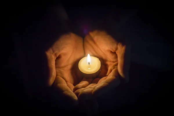 Mãos segurando uma vela — Fotografia de Stock