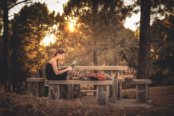 Молода жінка читає книгу в лісі — стокове фото