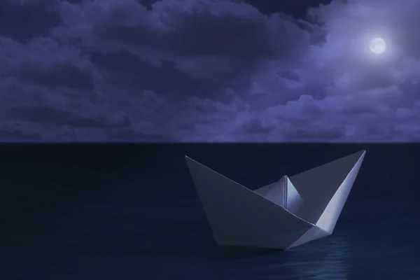 Paper boat floating in the sea at night — Stock Photo, Image
