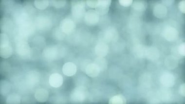 Defocused blue christmas background of falling animated shiny particles