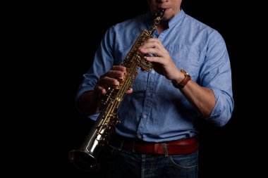 Erkek saksafoncu siyah arka planda soprano saksafon çalıyor, Jazz müzisyeni.