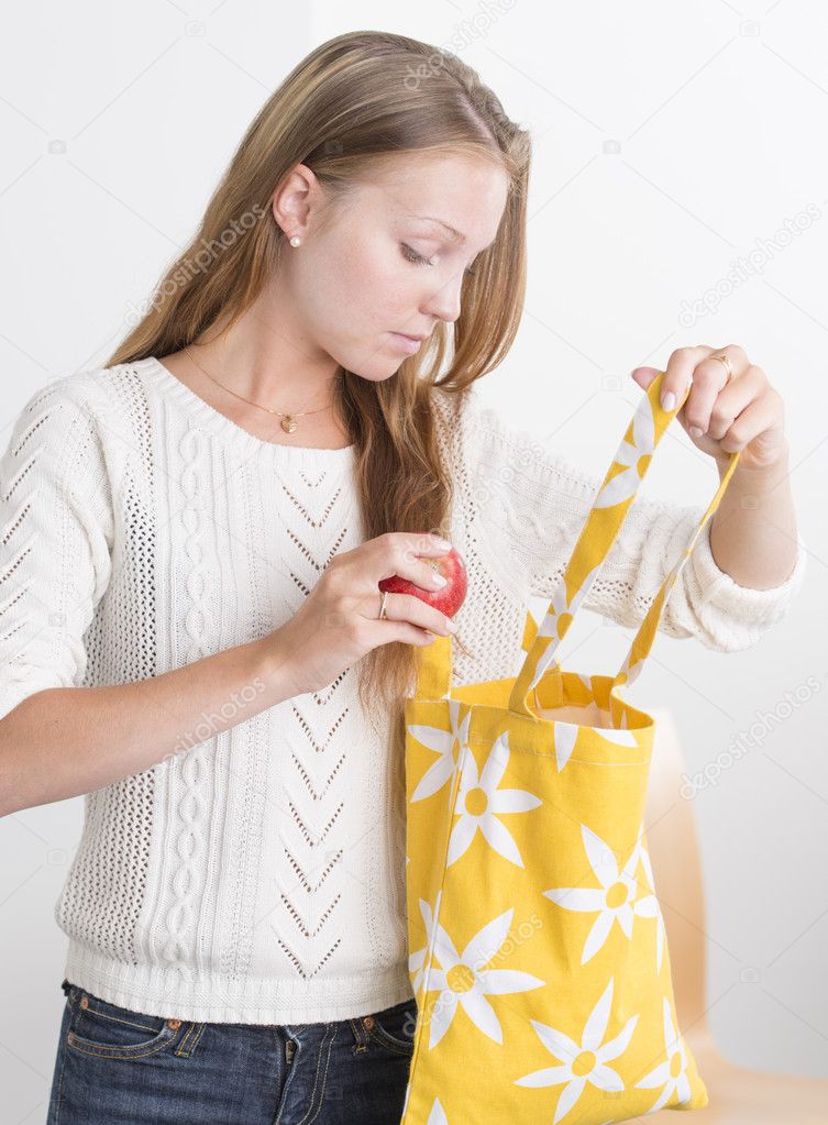 Young confident woman with reusable shopping bag