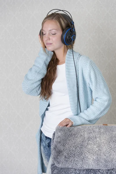 Schöne junge Frau mit Kopfhörern, die Musik hört — Stockfoto