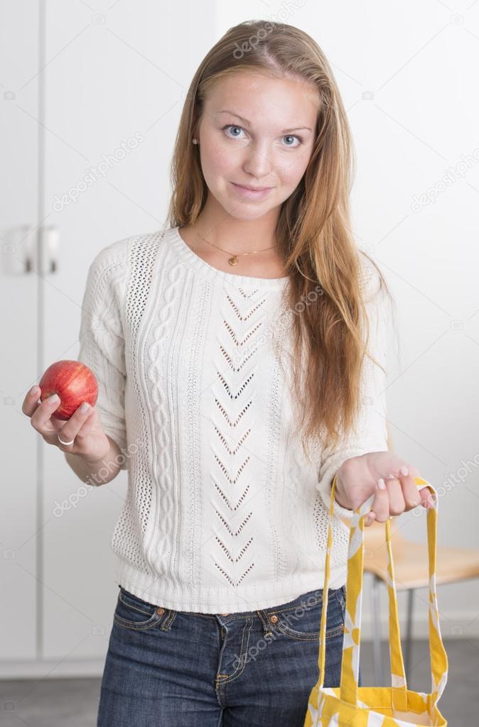 Young confident woman with reusable shopping bag