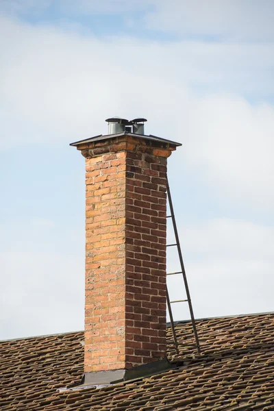 Rode bakstenen schoorsteen op dak van oude huis — Stockfoto